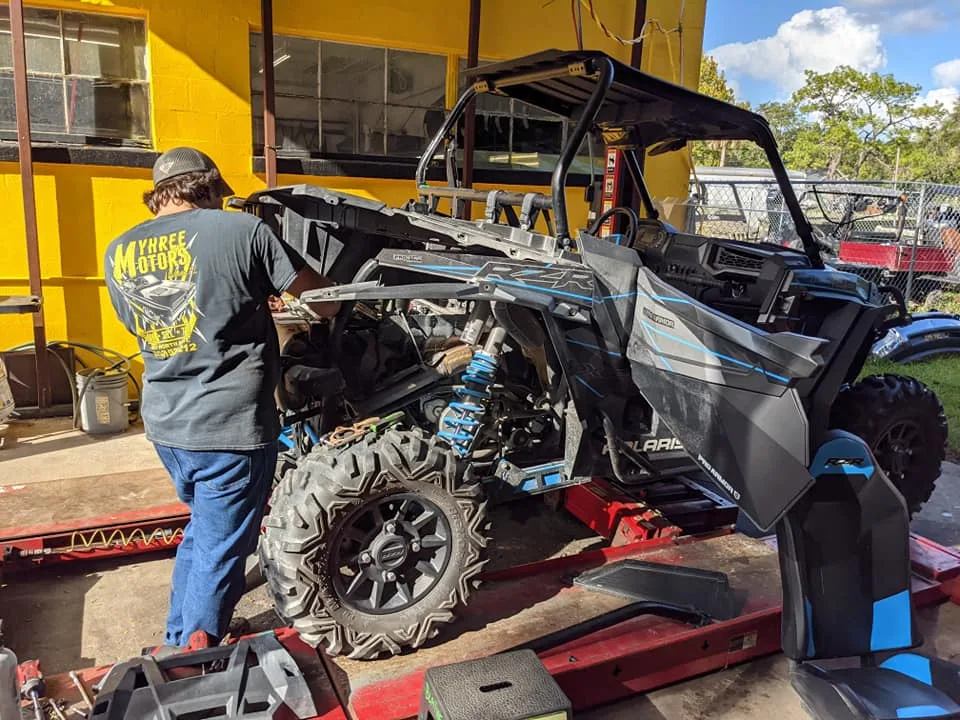 A TMT Offroad technician working on a Polaris side-by-side inside the shop in Williston, FL