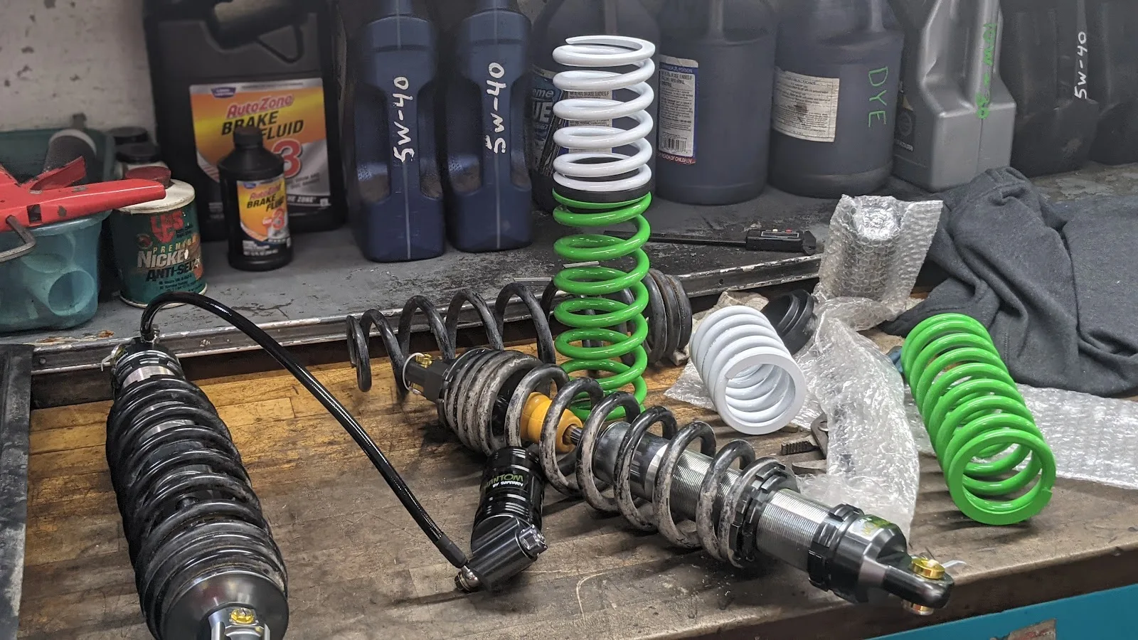 Aftermarket UTV shocks and springs laid out on the bench ready for a suspension install at TMT Offroad in Williston, FL